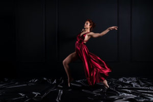 Ballerina dancing in dark red velvet dress