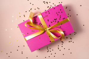 Pink present wrapped with gold ribbon